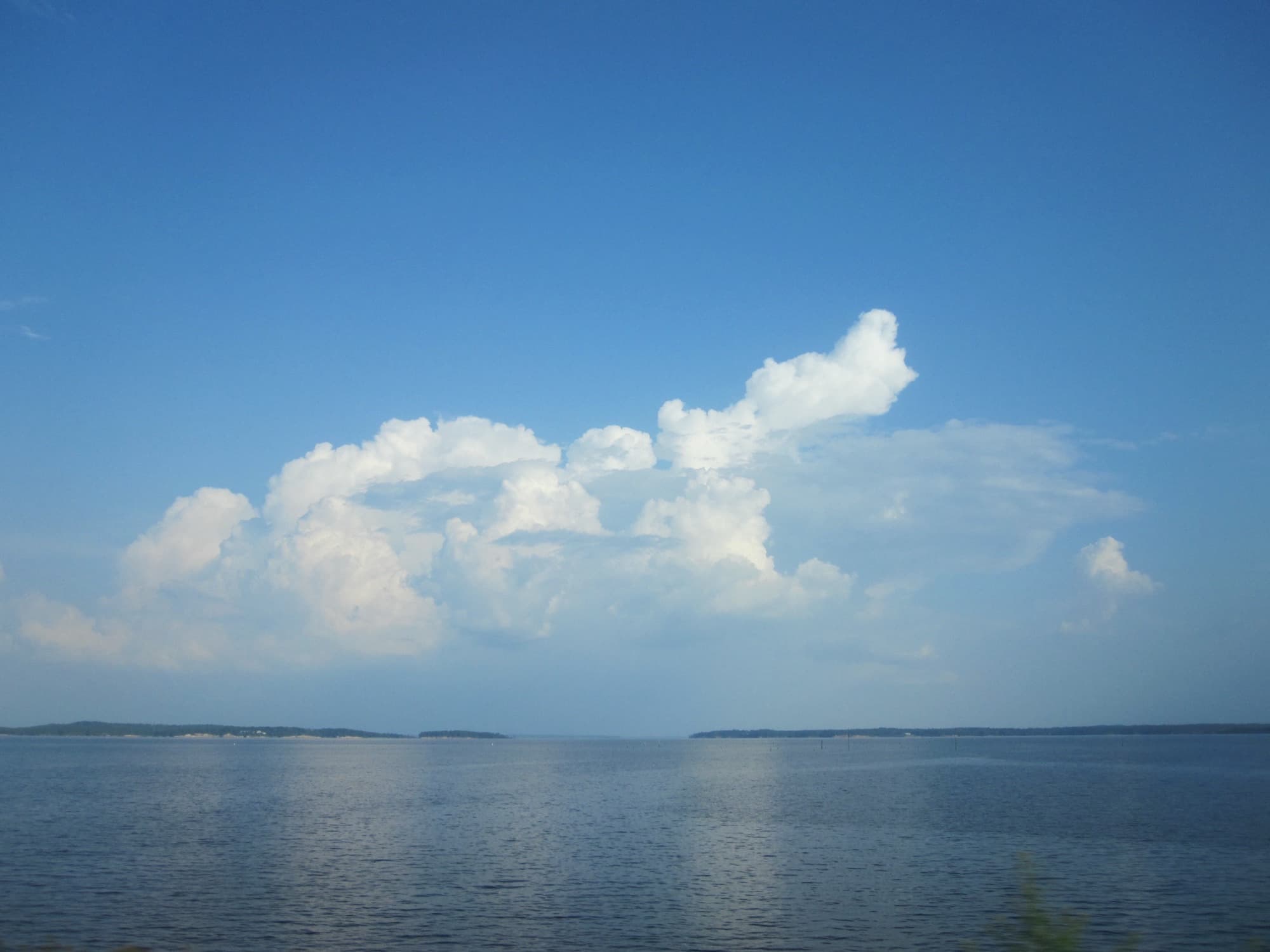 Open blue water and towering cumulus clouds over Toledo Bend Reservoir on the Texas-Louisiana border